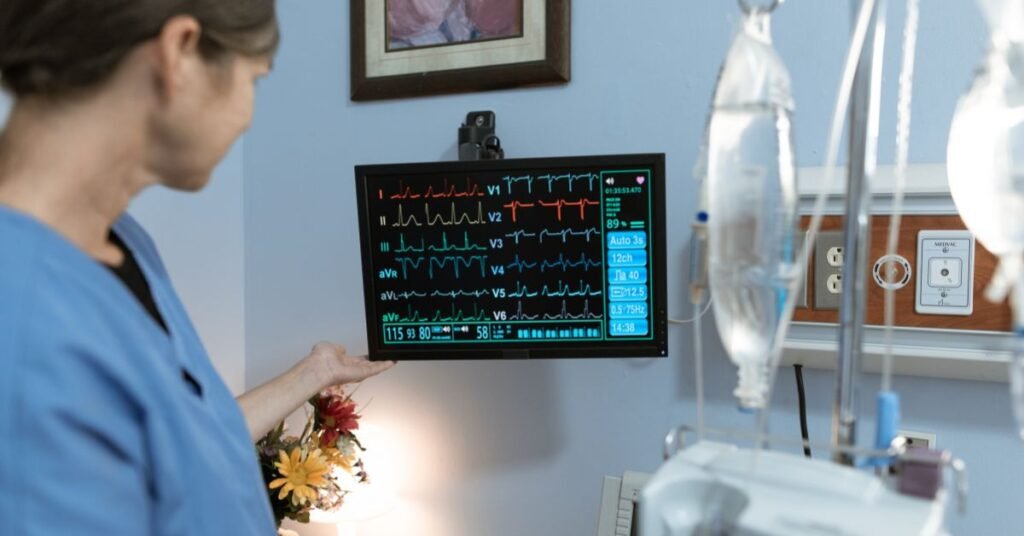Patient monitor displaying ECG and vital signs in hospital room