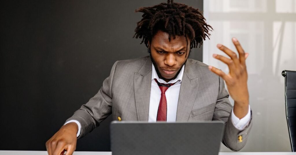 Frustrated man working on laptop at desk