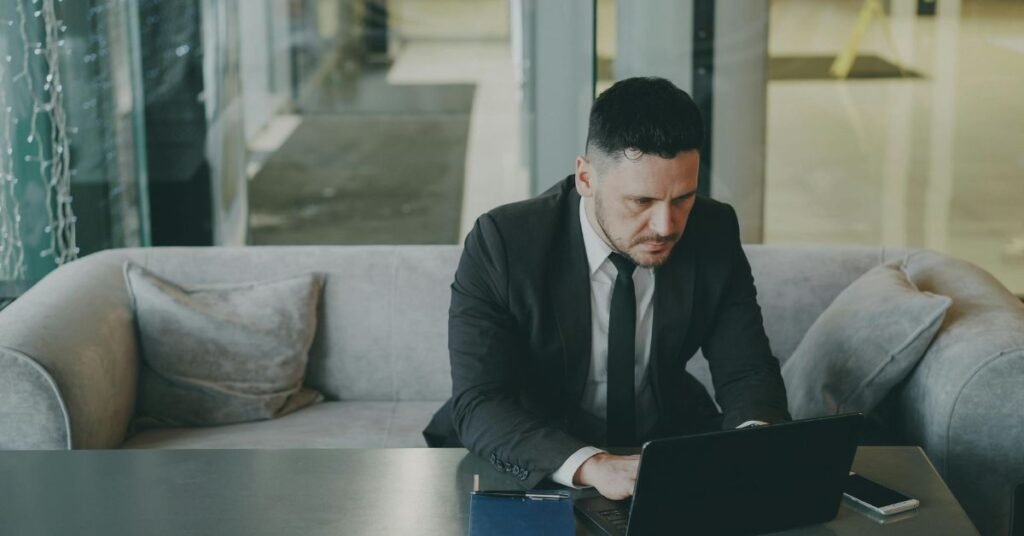 Businessman working on laptop in office lounge