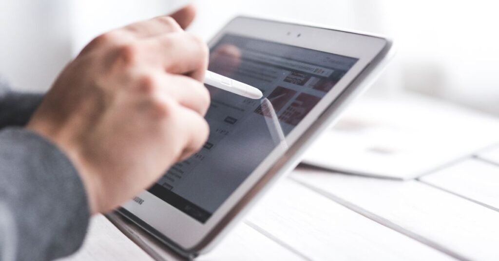 Person using a tablet with stylus pen for digital learning and tech work
